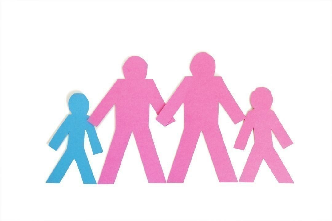 Row of paper stick figures holding hands over white background