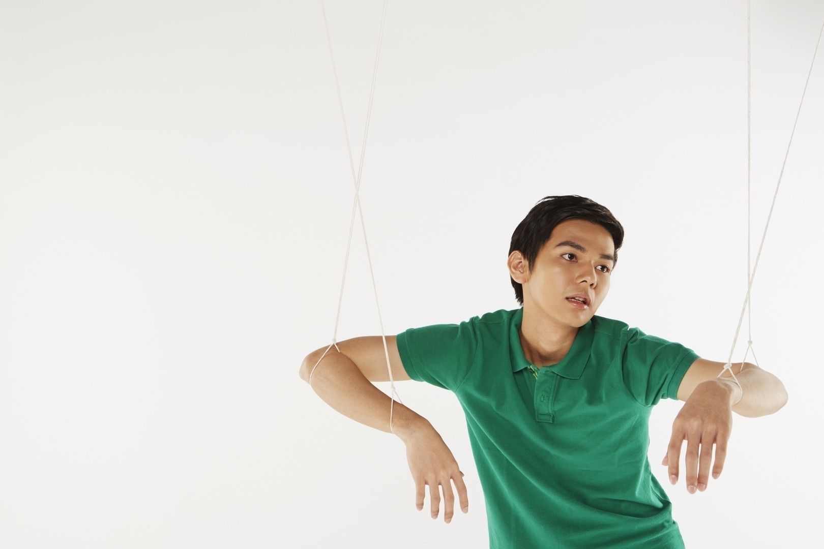Man being pulled by strings, like a puppet