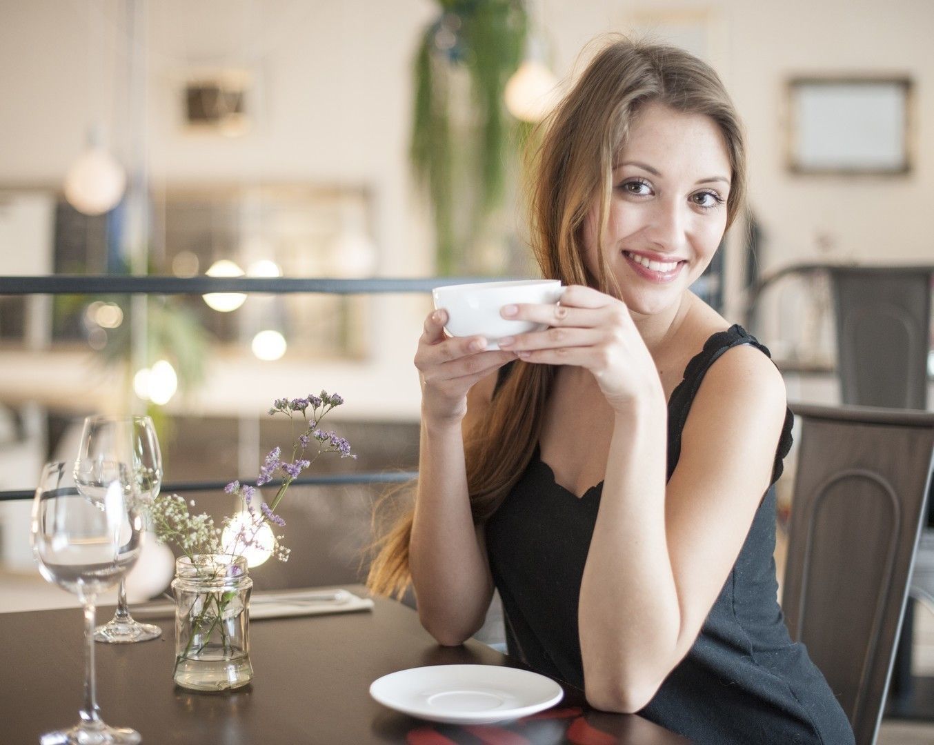 Portrait of happy young woman having coffee at restaurant