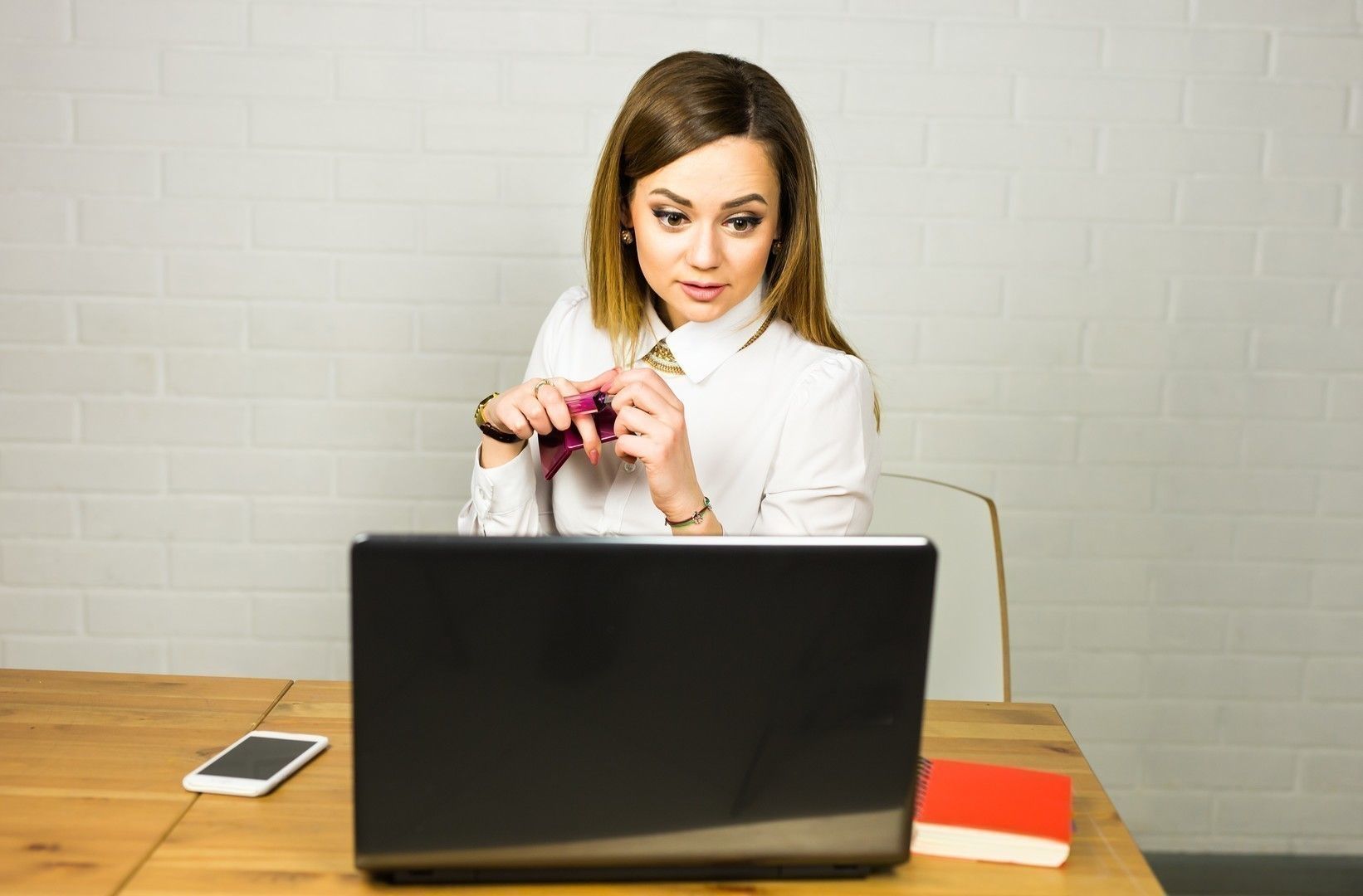 Portrait young shocked business woman sitting in front of laptop computer looking at screen. Funny face expression emotion feelings problem perception reaction.