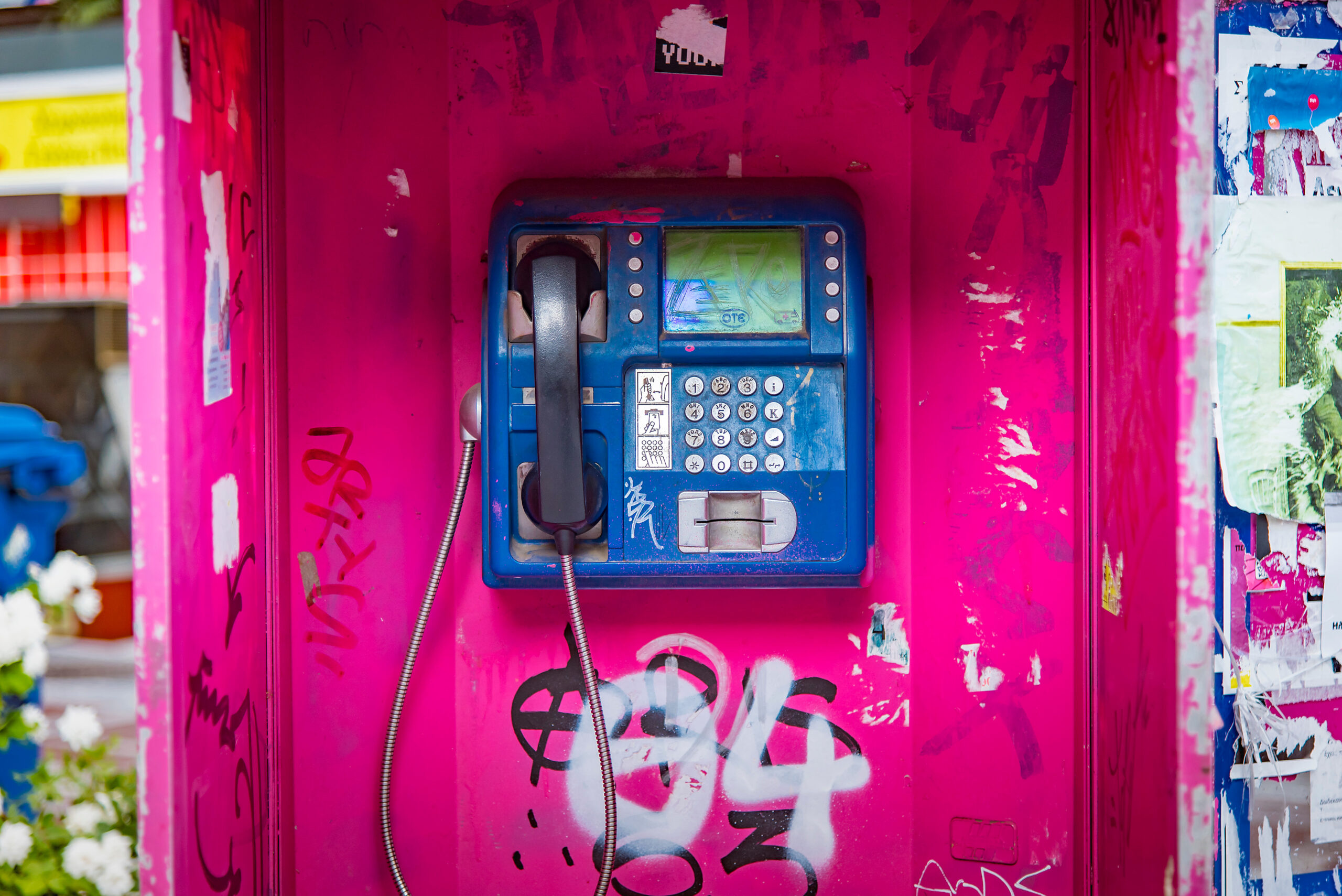 Old magenta phone booth sprayed with graffiti in Thessaloniki, G