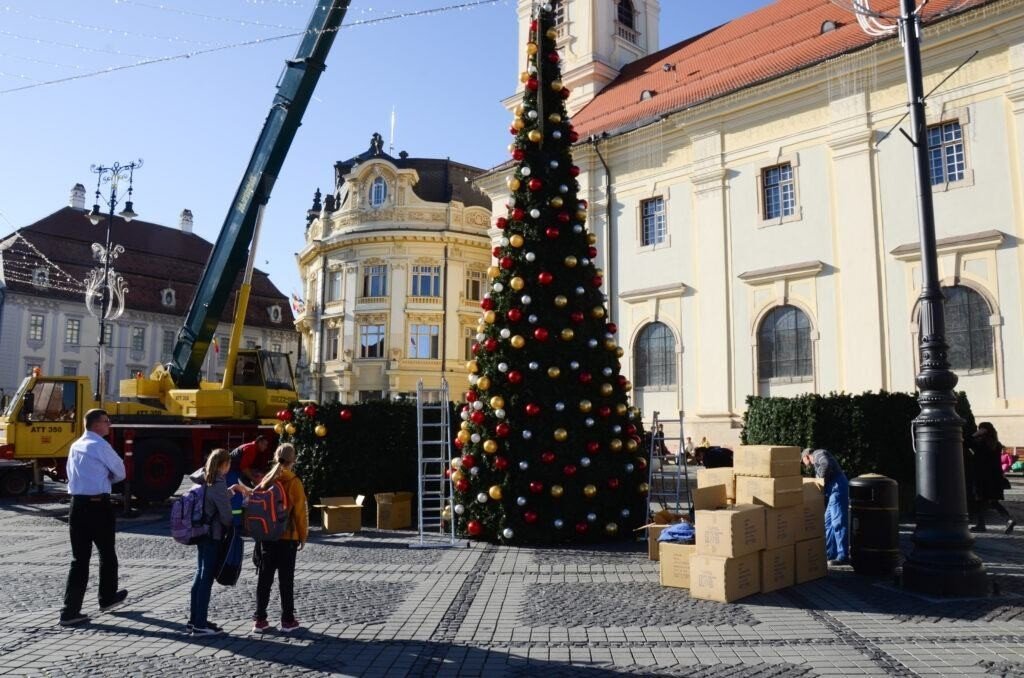 VIDEO-FOTO: Se montează bradul de Crăciun din Piața Mare. Reacțiile la cald ale sibienilor