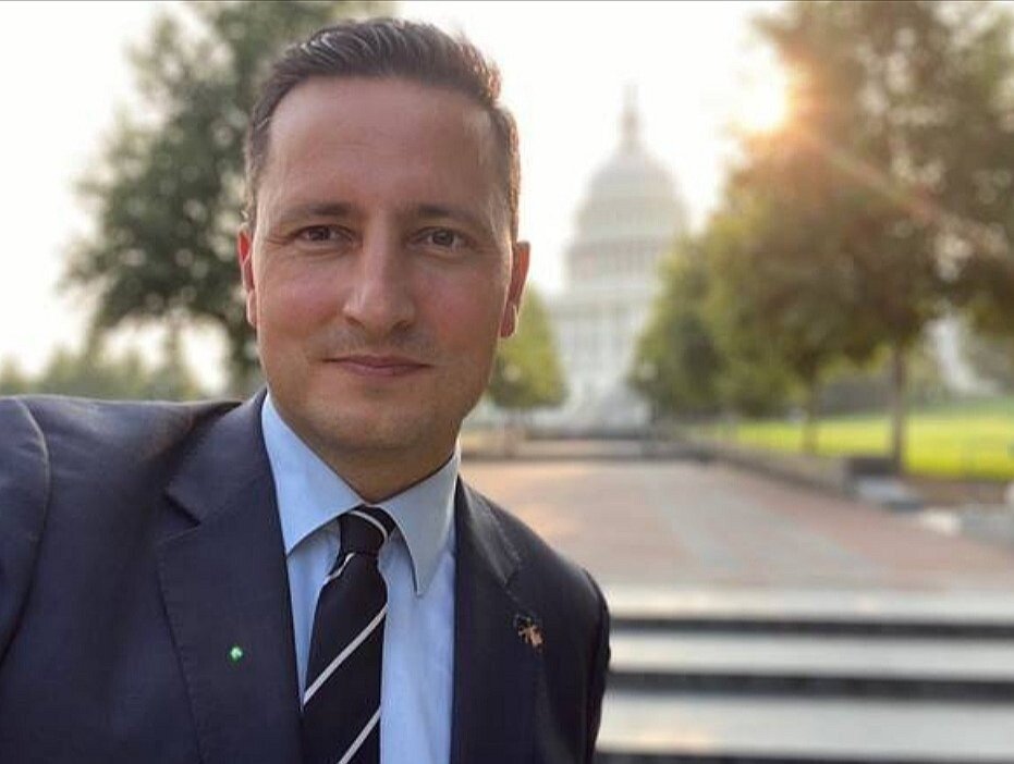 A person in a suit and tieDescription automatically generated with medium confidence