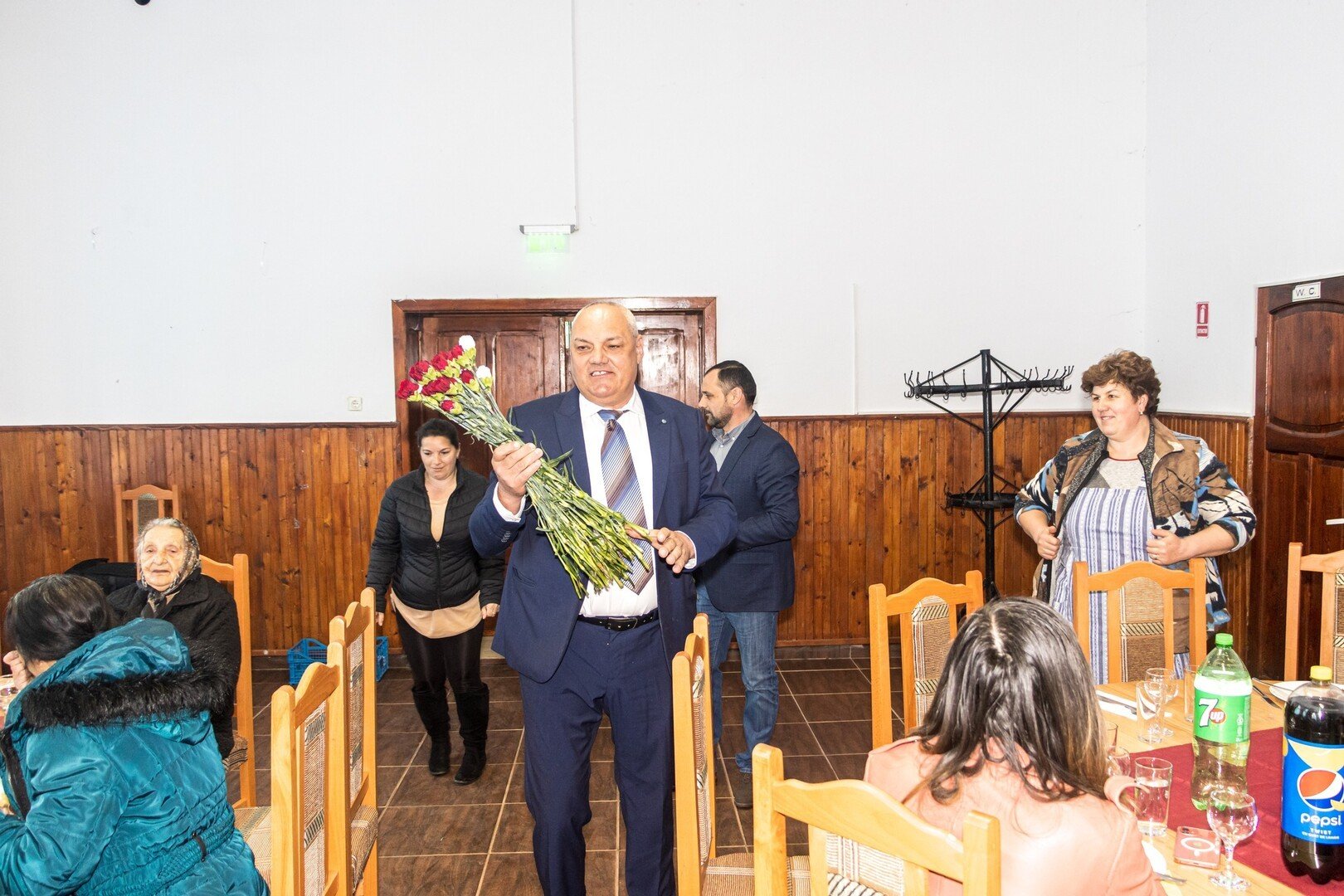 Primarul Nuțu de la Moșna ține un buchet de flori, pozând oficial