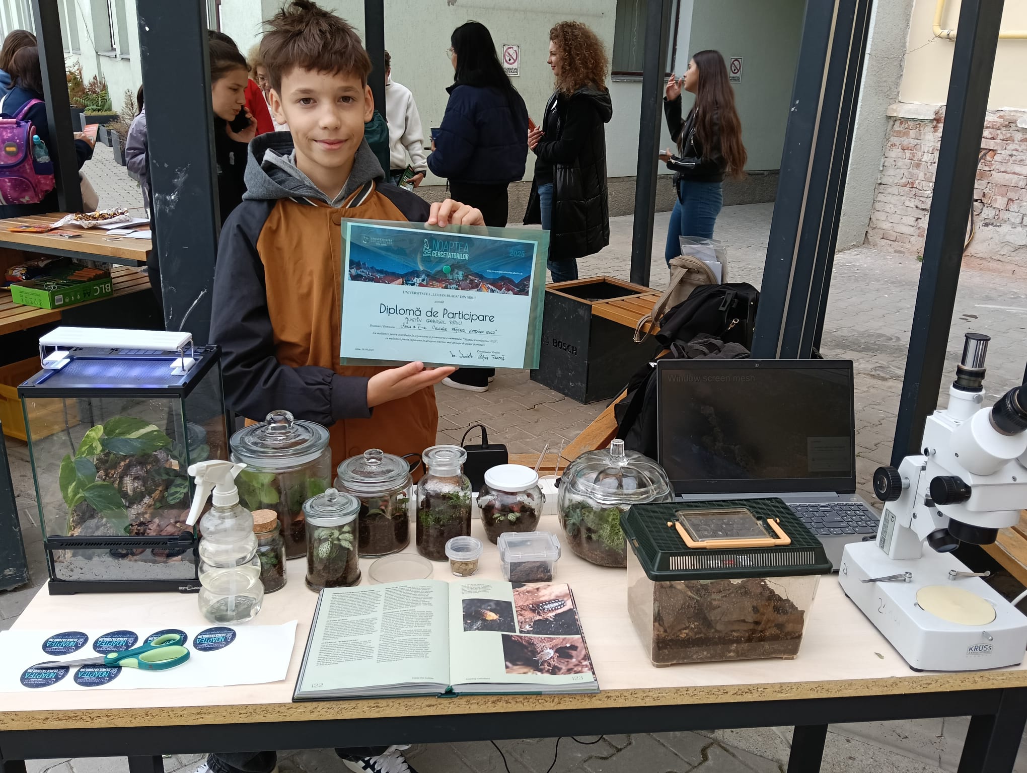 Elevul Justin Gabriel Radu prezintă cu entuziasm un proiect de biologie la o expoziție școlară