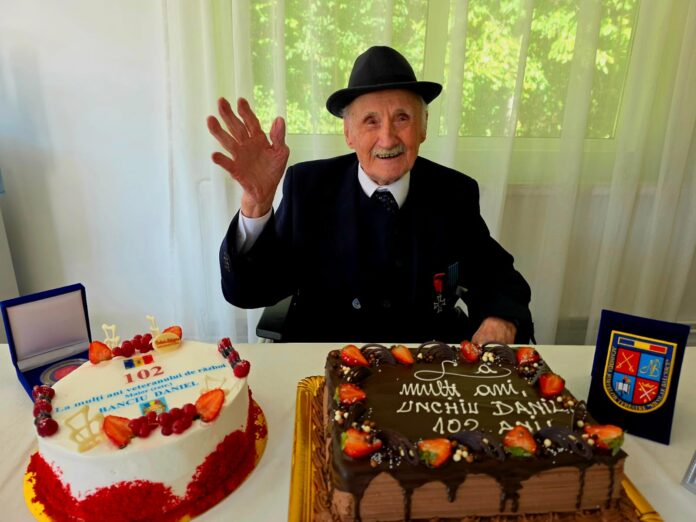 Veteran de război Danil Banciu, 102 ani, zâmbind în interior, purtând medalii pe costum