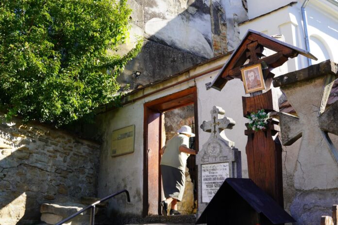 Vedere exterioară a Bisericii din Săsăuș cu acoperișul și turnul clopotniță