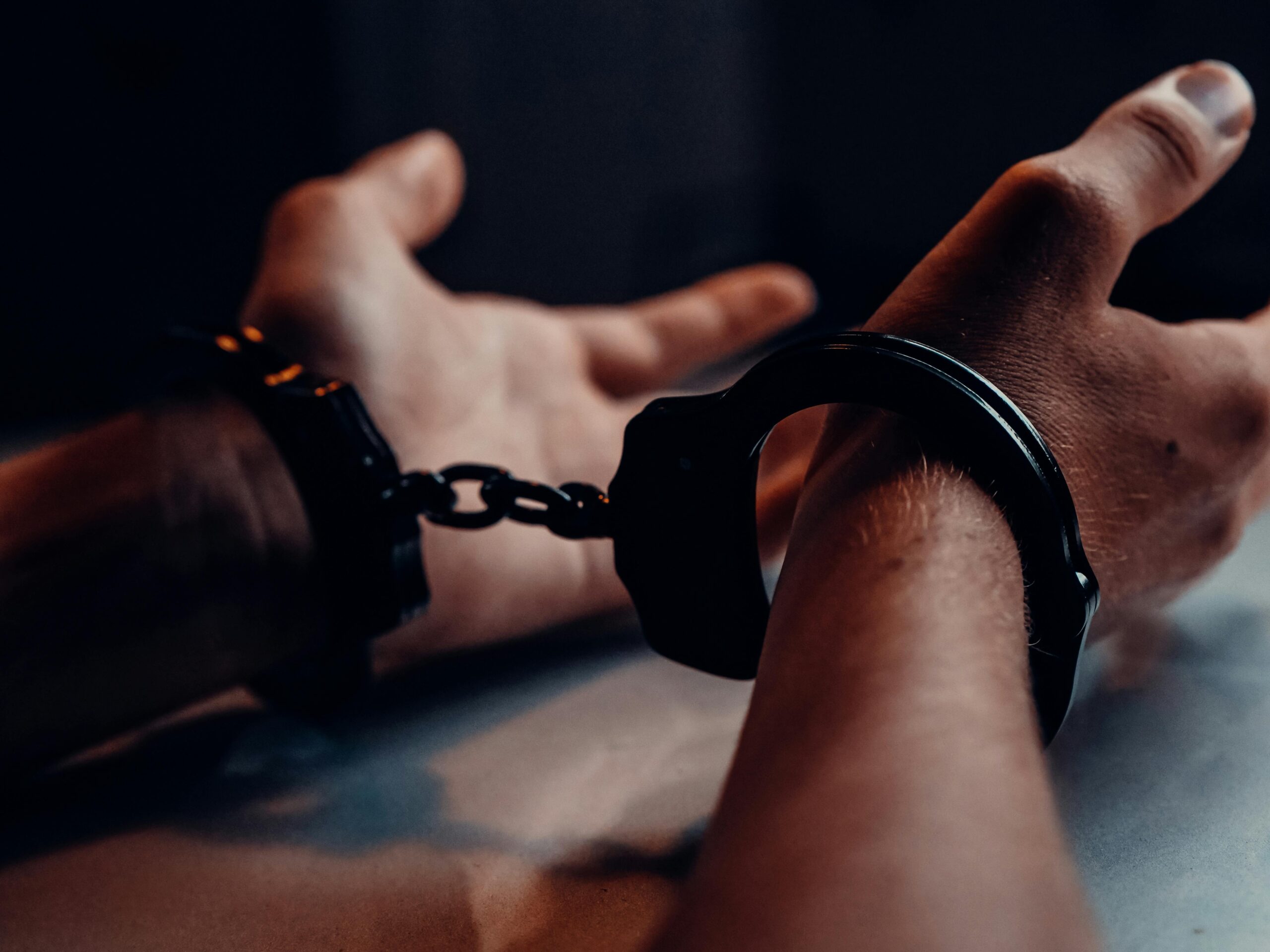Cătușe așezate pe masă, ilustrând arestarea pentru infracțiuni rutiere și violență în familie