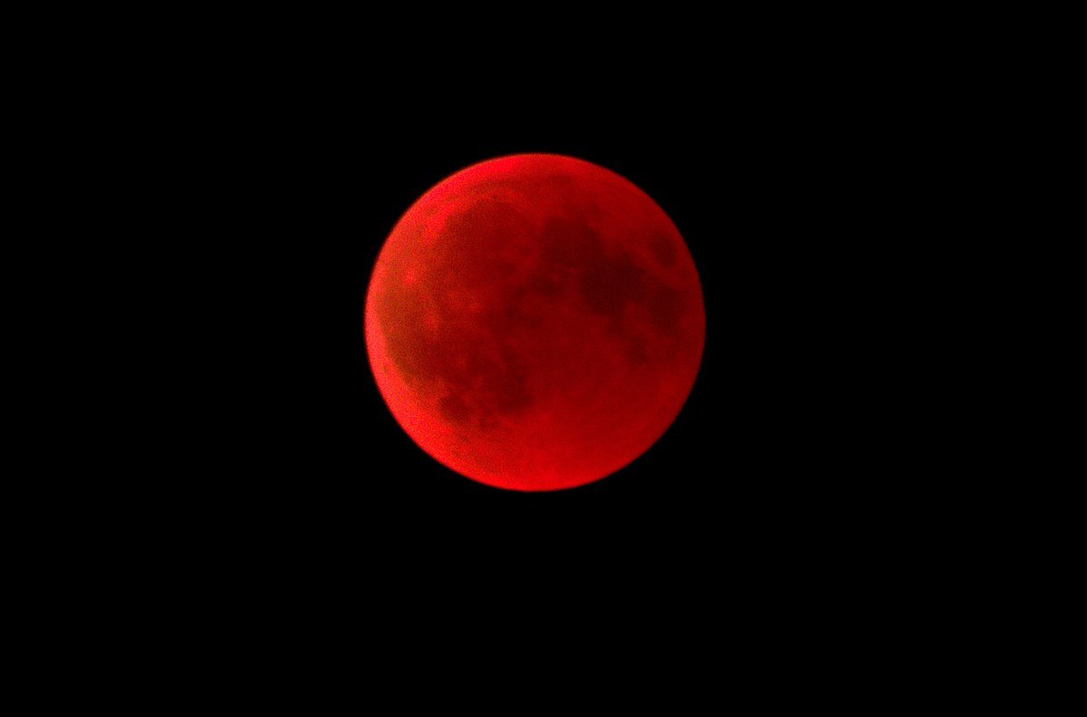Luna sangerie plina, eclipsata, vizibila deasupra orasului Sibiu pe cerul noptii