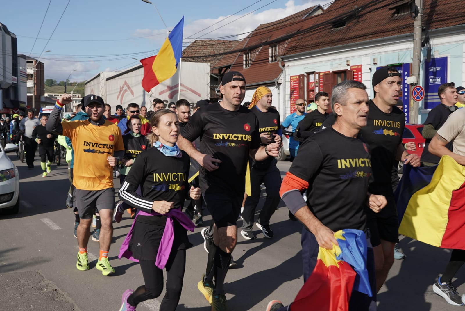 Veterani purtând steagul Ștafetei Invictus pe o uliță din Mediaș