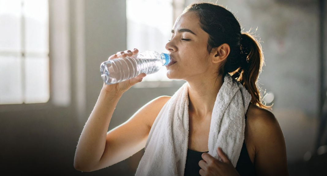 image Persoană epuizată după antrenament, stând pe o bancă la sală cu fața în mâini