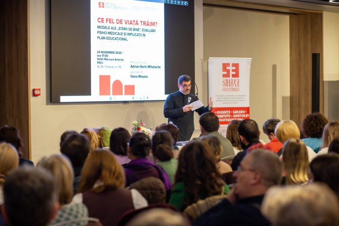 Profesori din Sibiu participă la o conferință despre starea de bine în educație, ascultând cu atenție un prezentator.