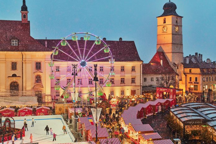 Târgul de Crăciun din Sibiu cu bradul iluminat și tarabe tradiționale, oferind acces îmbunătățit.