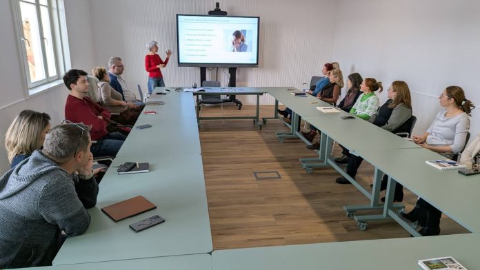 Angajați ai Consiliului Județean Sibiu ascultând prezentarea la sesiunea de instruire privind prevenirea hărțuirii.