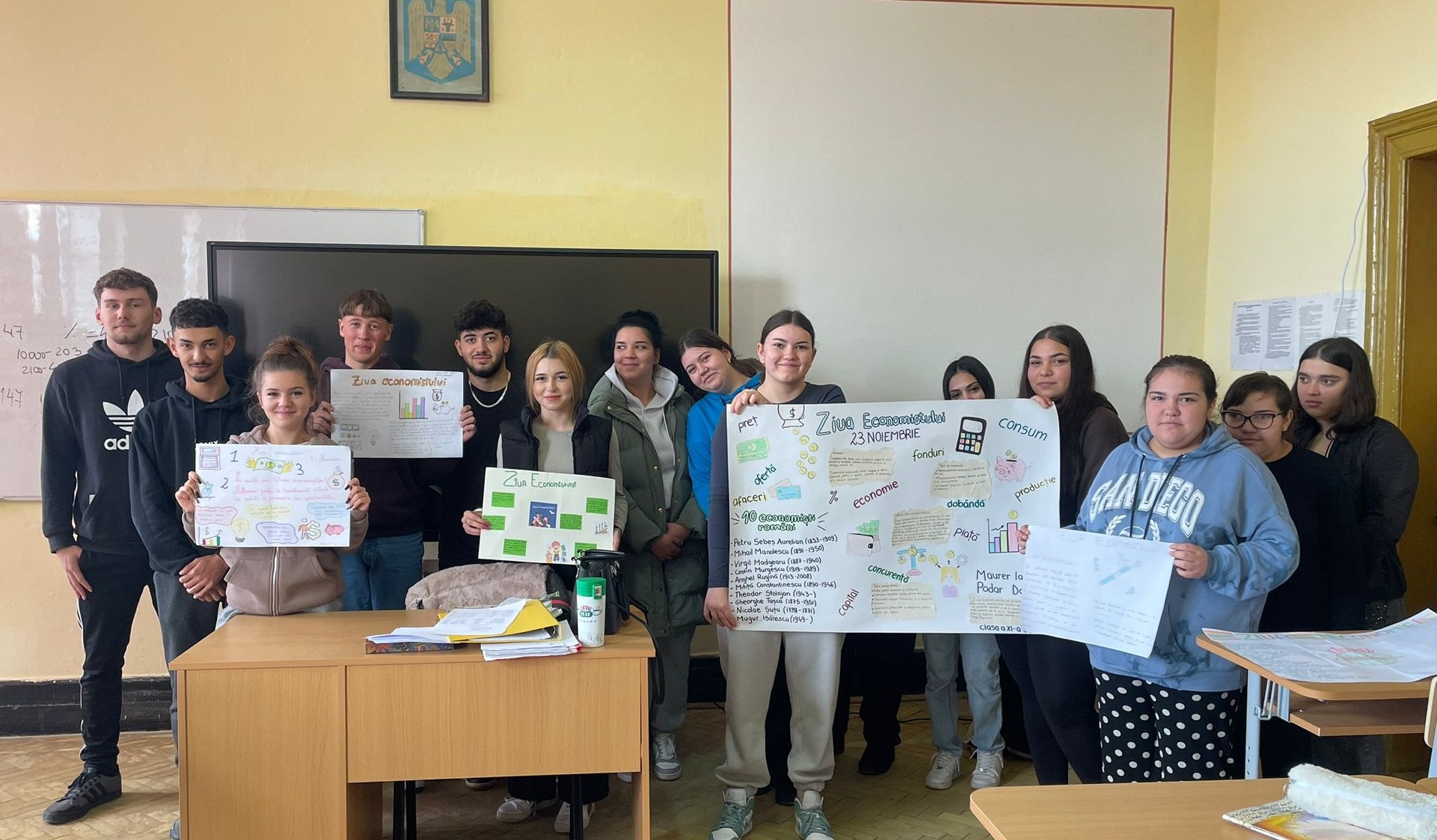 Elevi și profesori ai Liceului „Timotei Cipariu” Dumbrăveni sărbătoresc Ziua Economiei în sala de clasă.