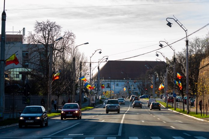 Steaguri ale României arborate pe străzile principale din Sibiu, pregătite pentru Ziua Națională.