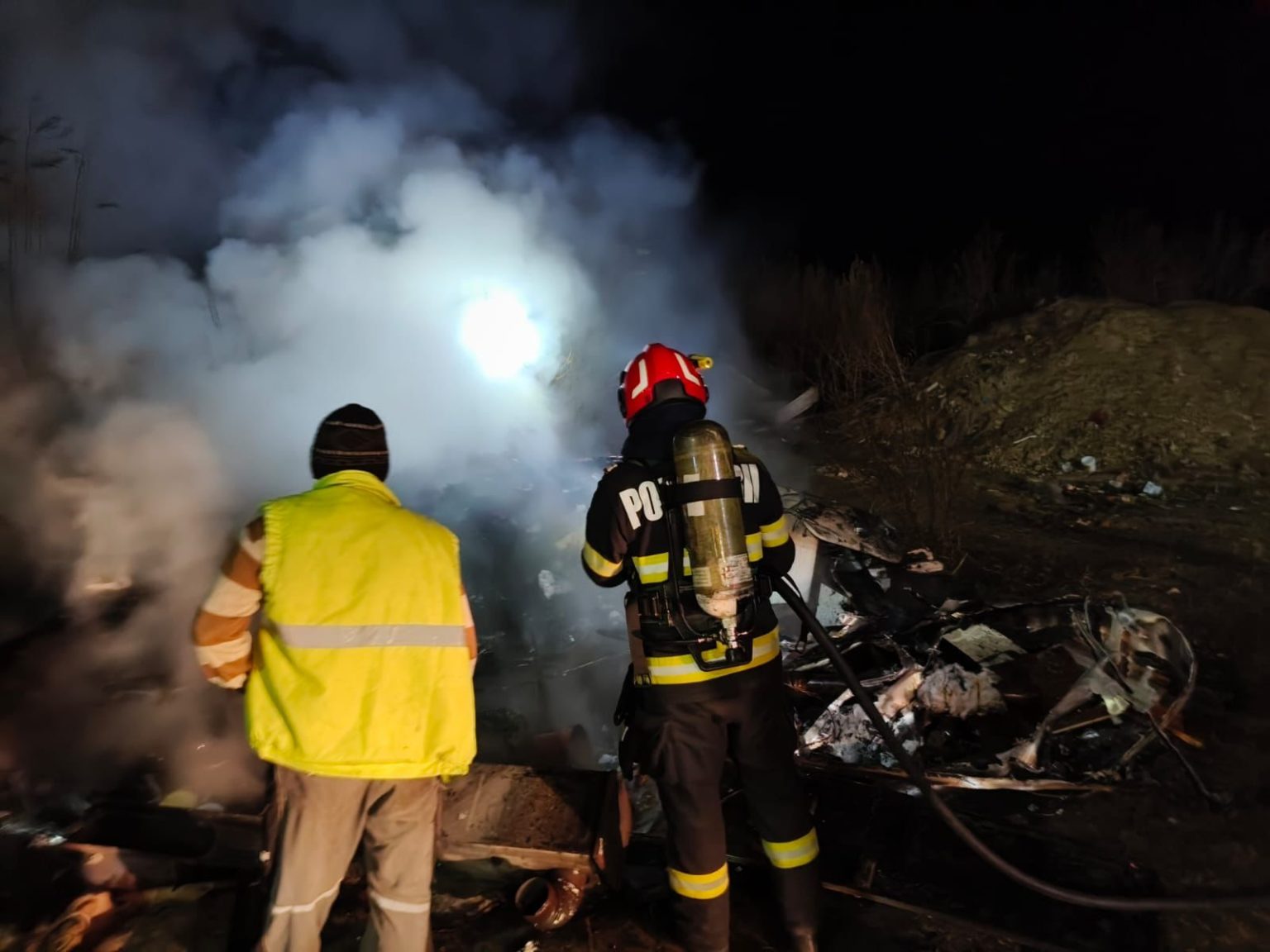 Două persoane în fața rulotei avariate de incendiu, necesitând ajutor în Ocna Sibiului