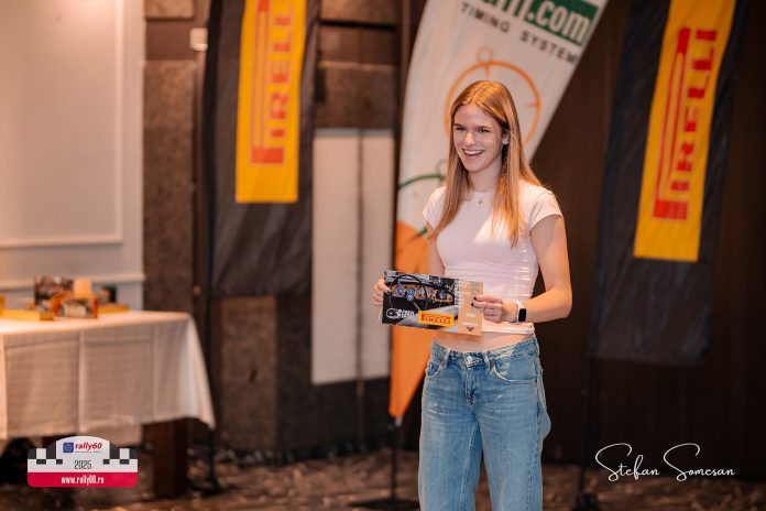 Ioana Fulea, voluntar la raliuri, primește trofeul de voluntarul anului cu un zâmbet larg.