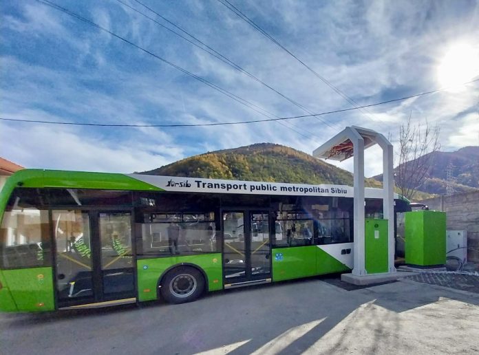 Autobuz verde în stație pe ruta spre Sadu, așteptând pasageri.