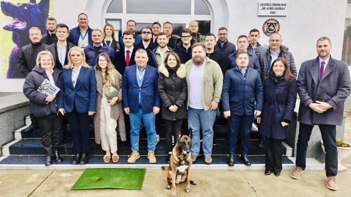 Cursanți observând un câine de serviciu în timpul unei demonstrații de dresaj