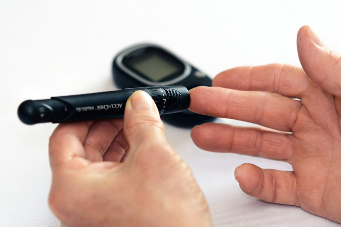 Persoană care își verifică nivelul glicemiei cu un glucometru, pentru Ziua Mondială a Diabetului.