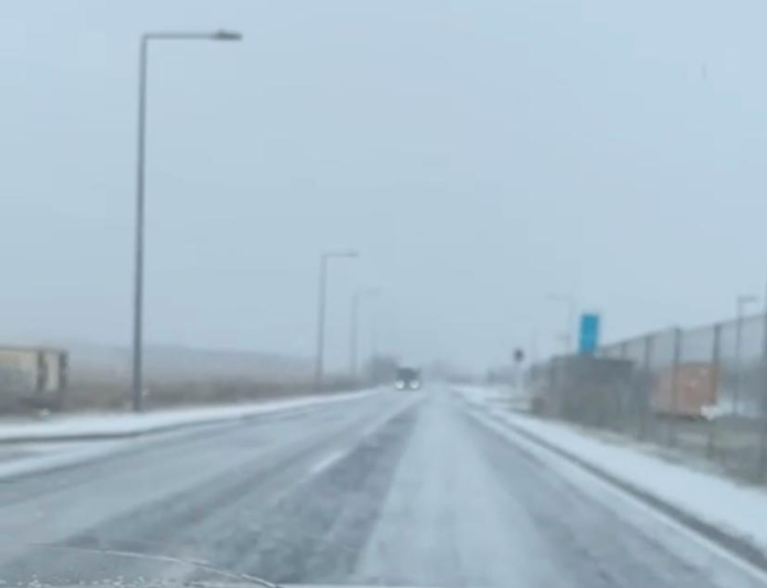 Mașină poliție IPJ Sibiu pe șoseaua acoperită de zăpadă, cerând prudență în trafic