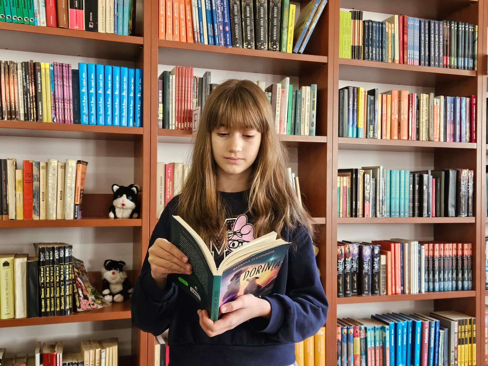 Raisa Dinuț ține trofeul și o carte, exemplificând pasiunea pentru lectură câștigătoare a maratonului.