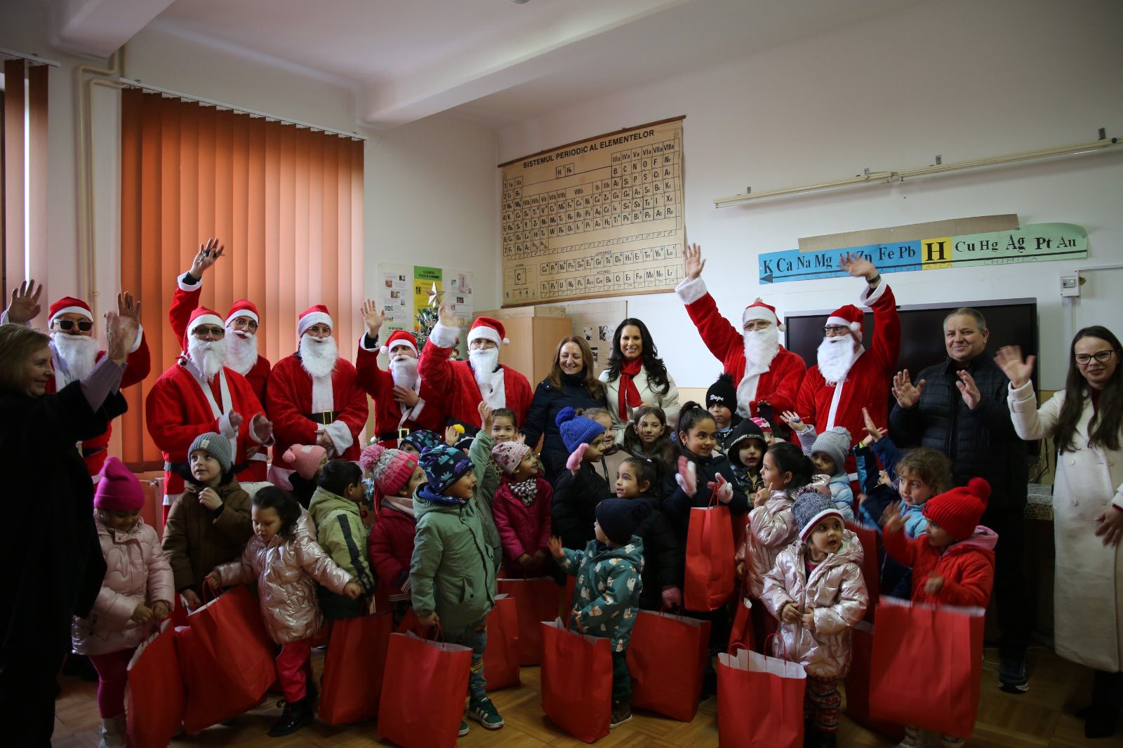 Interacțiune călduroasă între un Mos Crăciun voluntar și un copil care primește un cadou.
