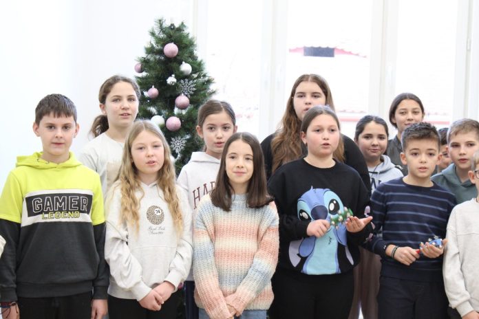 Colindători din Sibiu, bărbați și femei în costume populare, în timpul unei interpretări