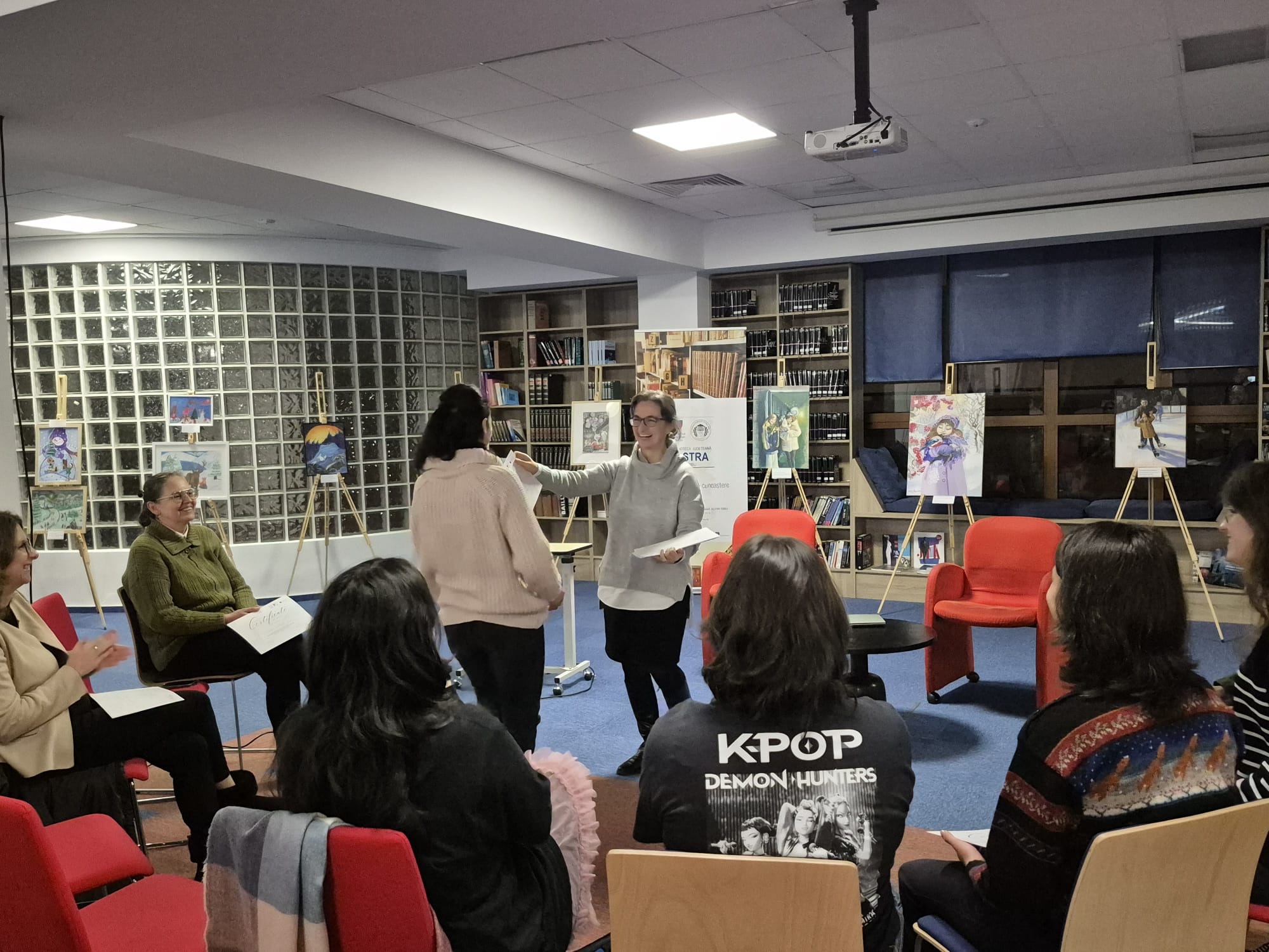 Tineri participanți la atelierul de public speaking de la Biblioteca ASTRA Sibiu, ascultând un prezentator.