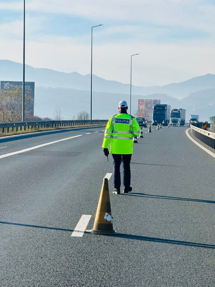 Polițiști efectuează un control rutier pe autostrada A1, verificând documentele unui șofer.