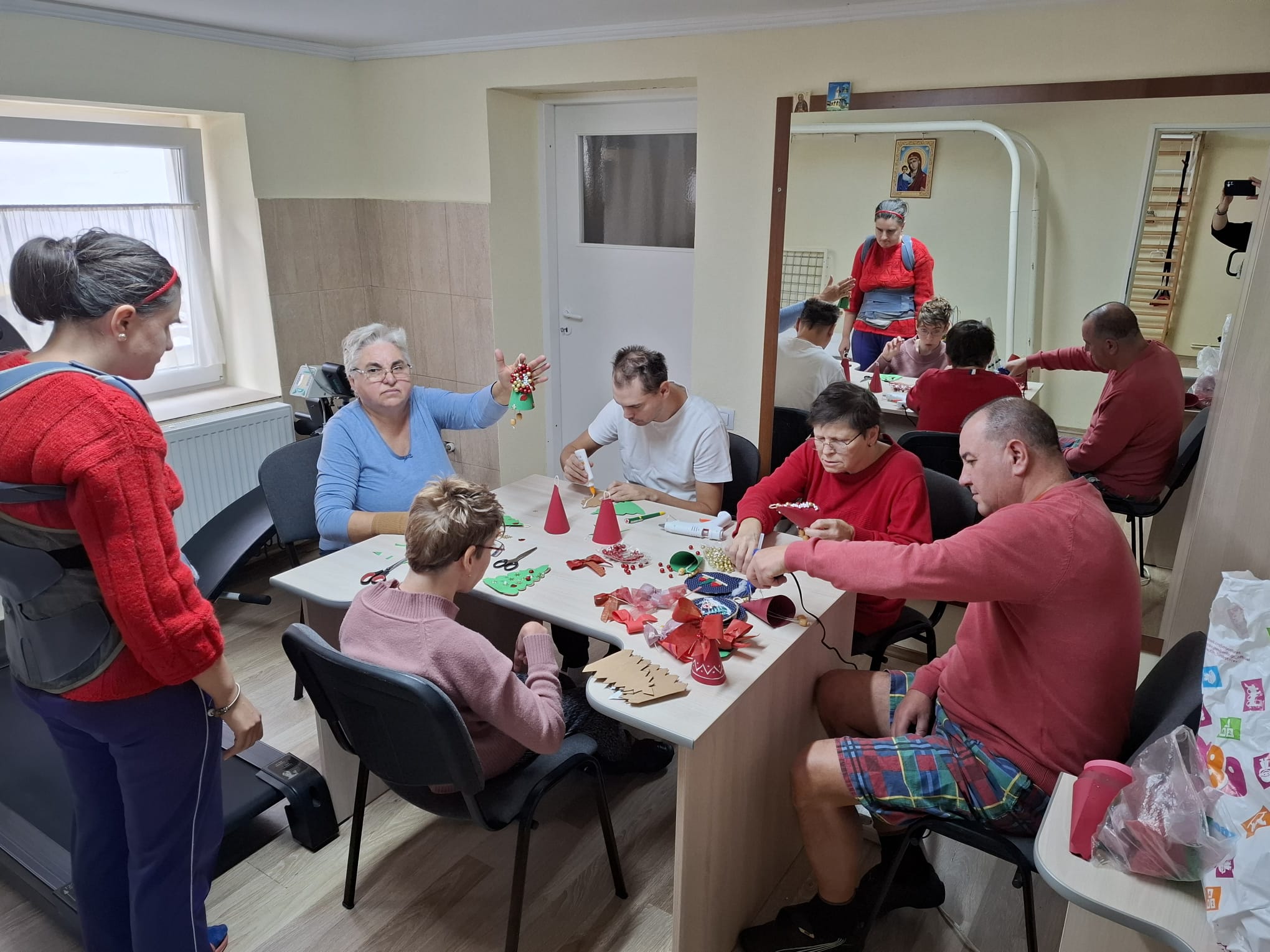 Persoană în scaun cu rotule concentrată pe pictură la atelierul de creație