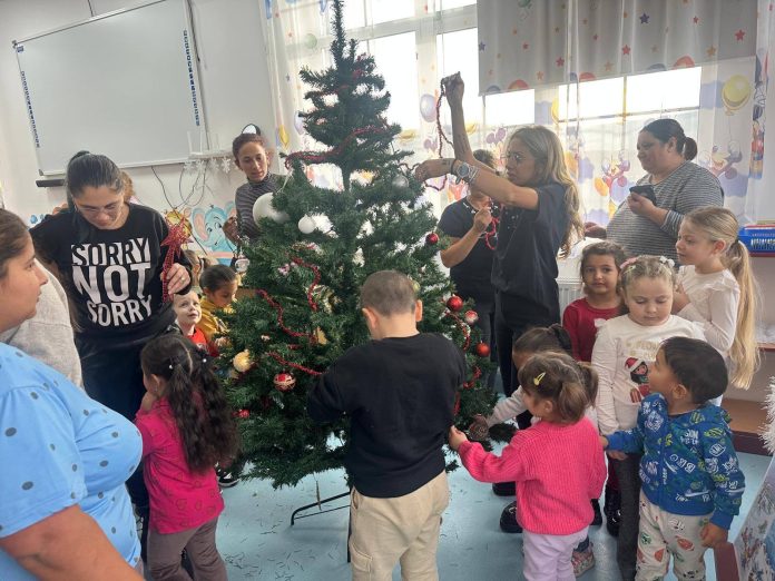 Îmbrățișare călduroasă între Moș Nicolae și un elev mic, simbolizând bucuria adusă în comunitatea educațională.