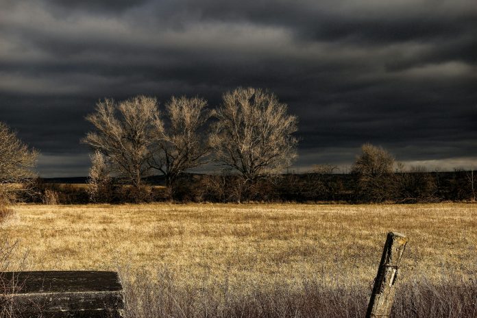 Vedere panoramică a unui peisaj de iarnă blândă în județul Sibiu, cu munții acoperiți de zăpadă sub un cer senin