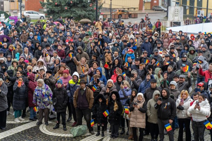 Oameni purtând tricoul tricolor la sărbătorirea Zilei Naționale în Mediaș