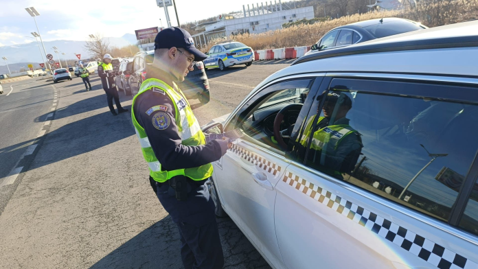 Polițist sibian operând radar de viteză pe un drum principal pentru combaterea vitezei excesive