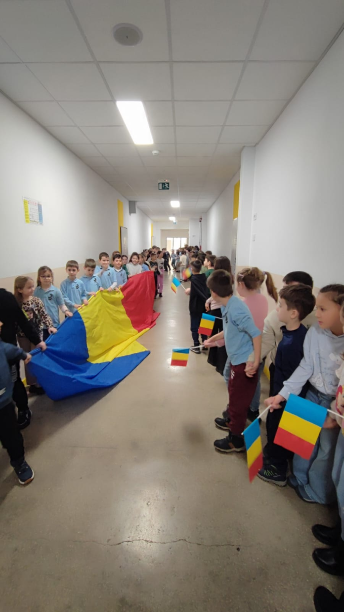 Hora Unirii la Școala Regele Ferdinand, cu elevi ținându-se de mână.