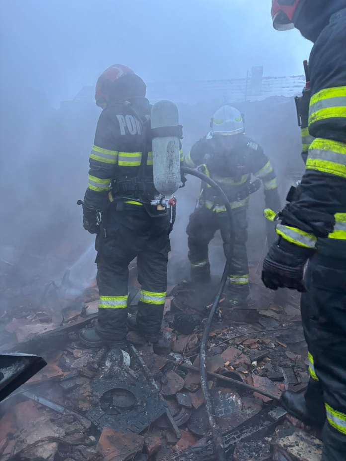 Rulotă distrusă de incendiu în satul Armeni, cu dărâmături carbonizate pe locul faului