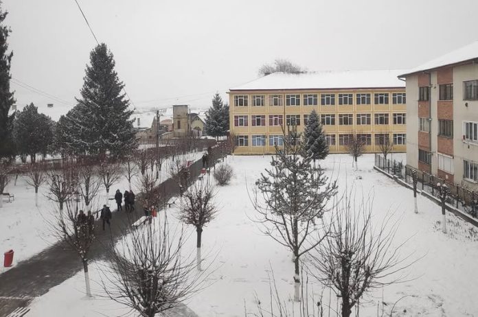 Liceul Teoretic Axente Sever Mediaș în timpul iernii, cu zăpadă pe acoperiș și în curtea școlii.
