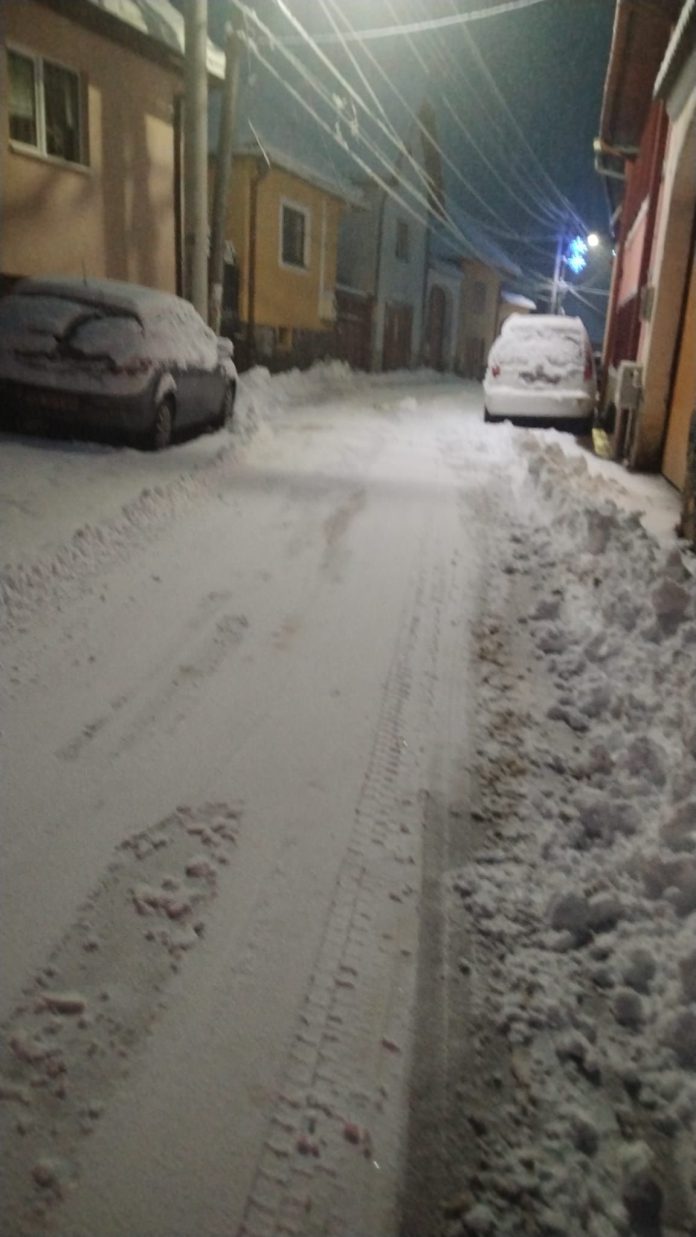 Un echipaj de primărie lucrează la deszăpezirea străzilor din Rășinari, curățând trotuarele de gheață și zăpadă.