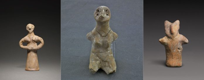 Figurină antropomorfă din cultură Vinča, cu trăsături geometrice stilizate, expusă pe un suport.
