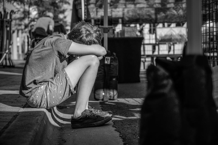 Tânăr în criză, privind printr-o fereastră, reflectând disperarea și tentativele de suicid la tineri din Sibiu.