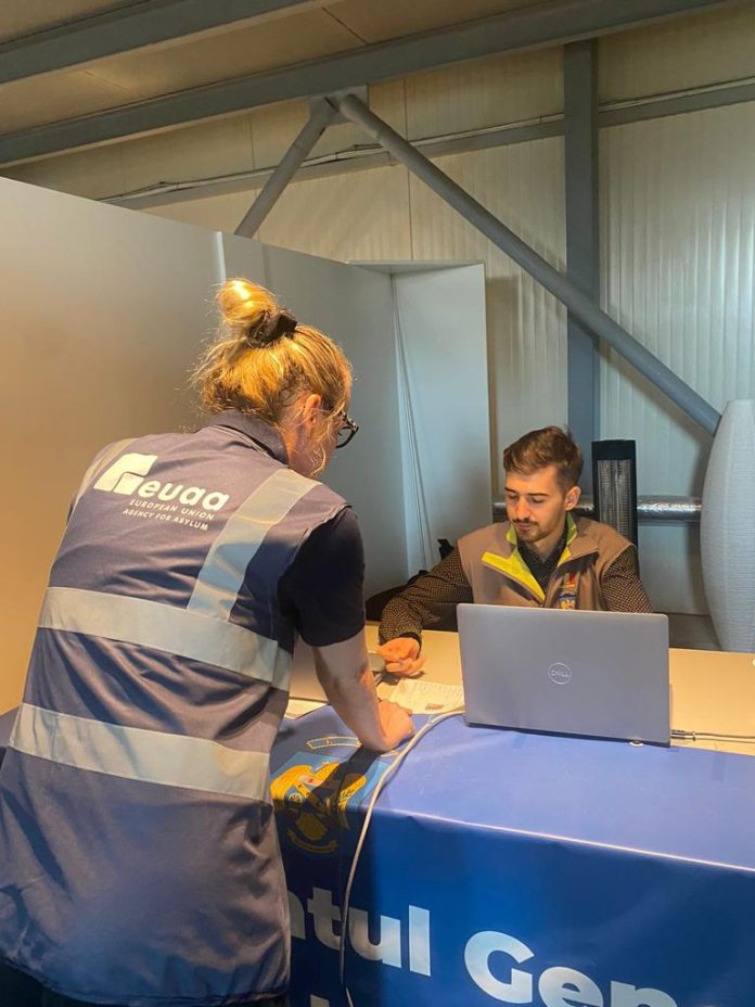 Ofițer român eliberând permise de ședere pentru refugiații din Ucraina