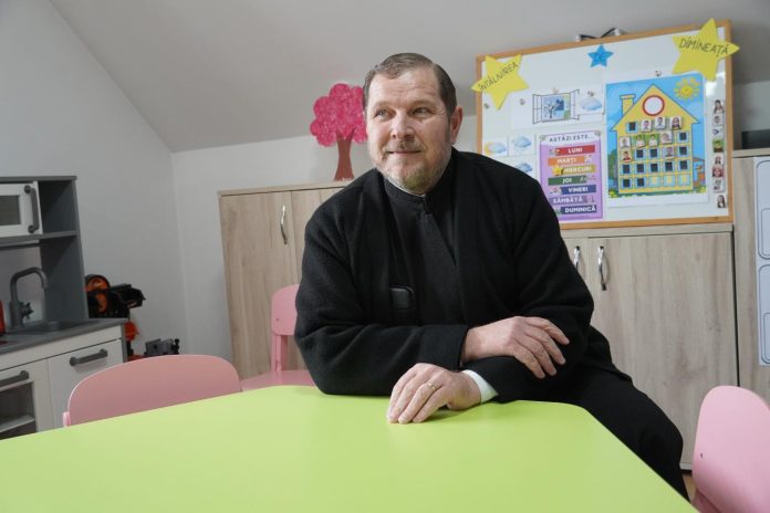 Tânărul preot Gafton, înainte de a deveni protopop, stând lângă un altar într-o biserică ortodoxă română.