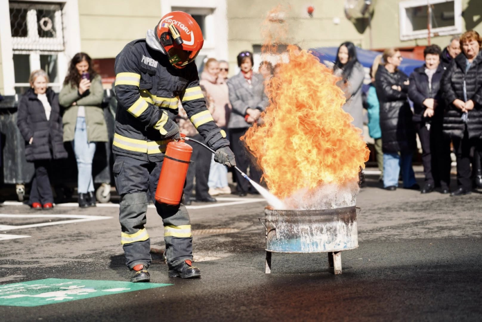 Participanți la exercițiul de evacuare ieșind ordonat din clădirea Consiliului Județean Sibiu