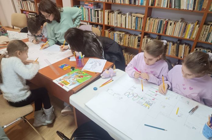 Atelier de creație unde copii sunt implicați în desenarea benzilor desenate olimpice