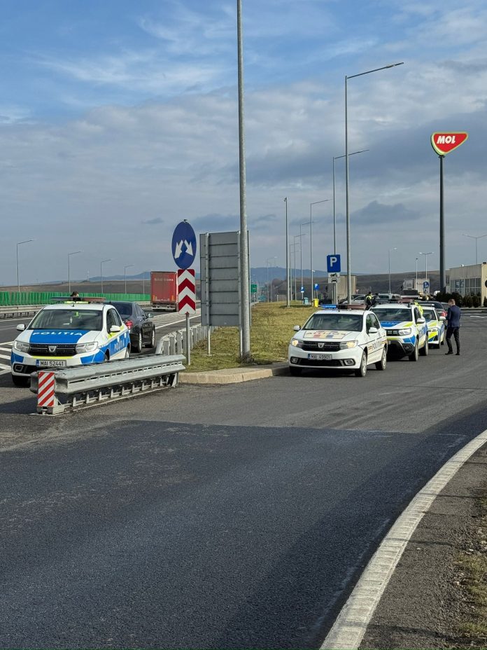 Polițiști controlând mașinile în timpul raziei pe autostrada A1, lângă un echipaj rutier