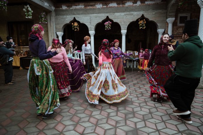Dansatori căldărași în costume colorate pe scena din Brateiu, spectacol de folclor