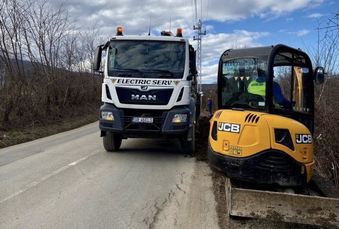 Lucrări de extindere rețea electrică cu stâlpi noi pe un deal din comuna Sadu