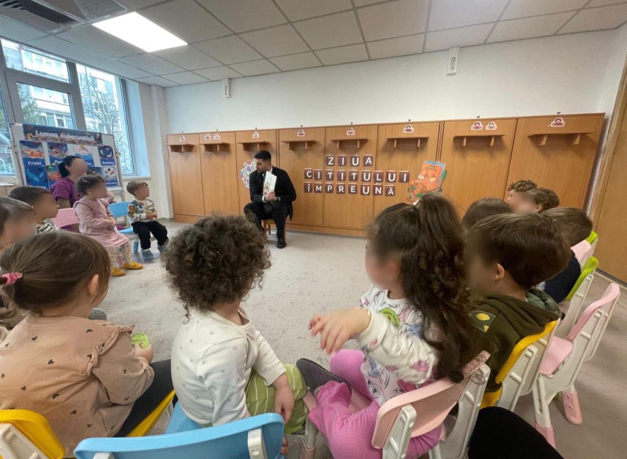 Subprefectul Florian Giubega citește o poveste unui grup de preșcolari entuziaști, de Ziua Internațională a Cititului Împreună